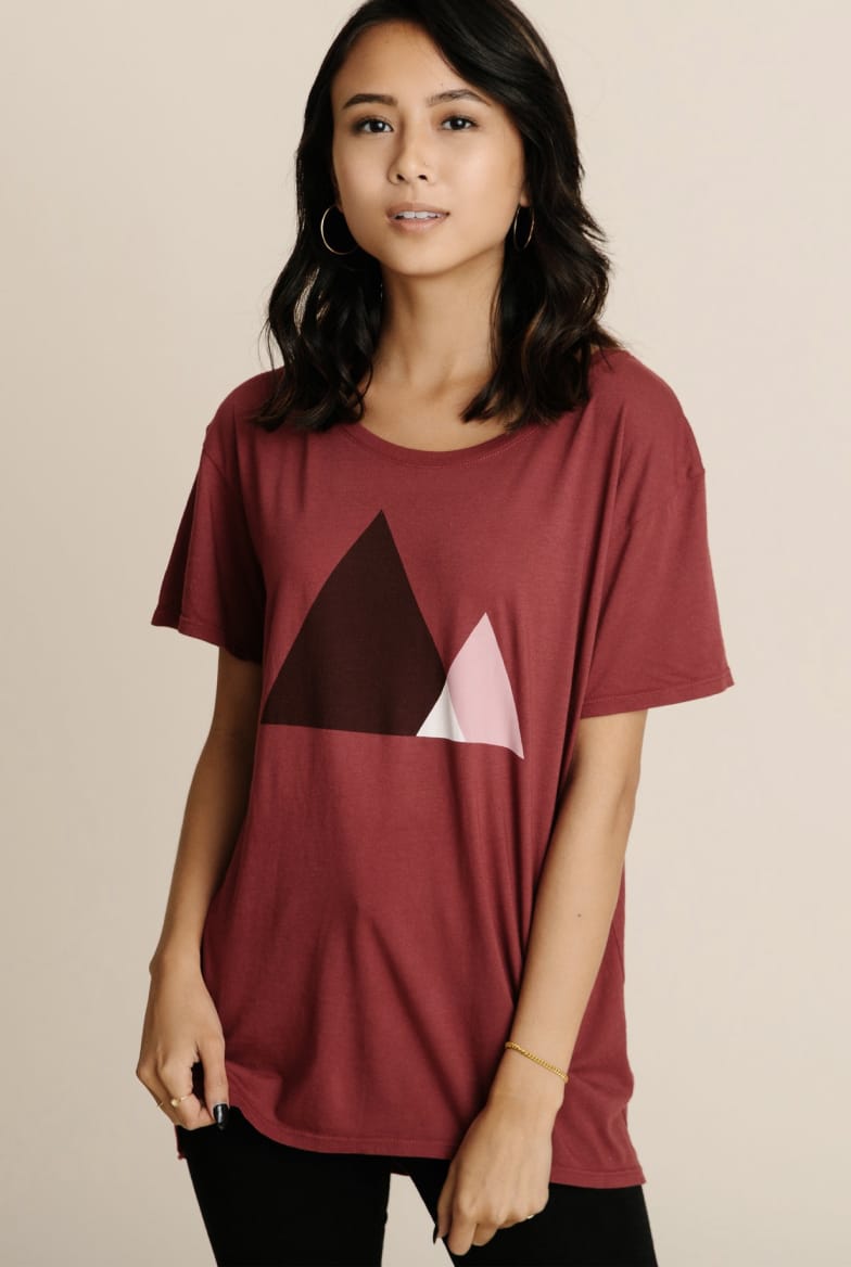 Model wearing women's burgundy red crewneck artwork tee.